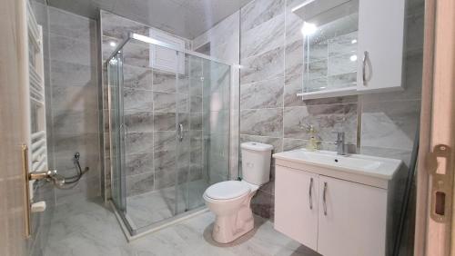 a bathroom with a toilet and a shower and a sink at Padishah Suite Otel in Van