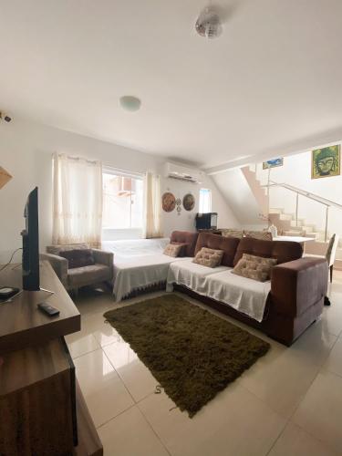 ein Wohnzimmer mit einem großen Bett und einem Sofa in der Unterkunft Casa Blue Horse Pipa in Pipa