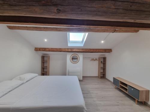 ein Schlafzimmer mit einem weißen Bett und einem Dachfenster in der Unterkunft Le Rawai in Fos-sur-Mer