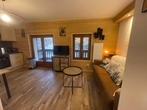 a living room with a couch and a table at Résidence La Ruche-Appartement ISOARD (T2) in Les Carroz d'Araches