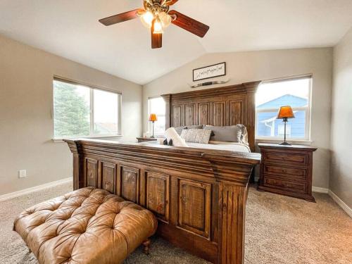 - une chambre avec un grand lit et un ventilateur de plafond dans l'établissement Bear Creek Retreat / mins to trails / central loc, à Colorado Springs