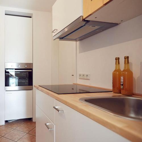 a kitchen with a sink and bottles on the counter at Ferienwohnung Tannen-Apotheke Eins in Mengerskirchen
