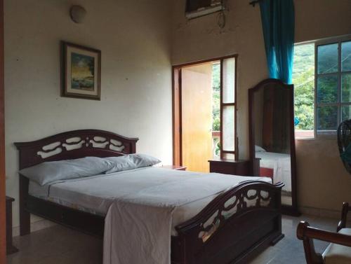 1 dormitorio con 1 cama grande en una habitación en Cabaña dulce sueños, en Taganga