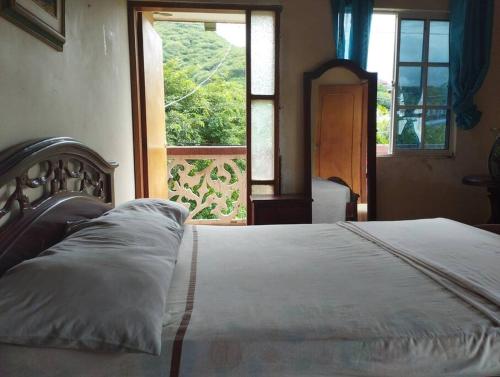 1 dormitorio con 1 cama blanca y ventana en Cabaña dulce sueños, en Taganga