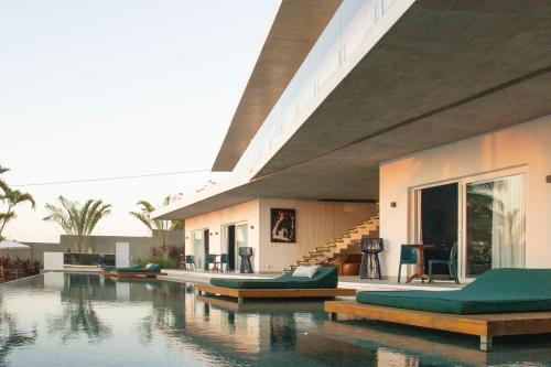 a house with a swimming pool with green furniture at The View - Adults Only Resort in Pipa