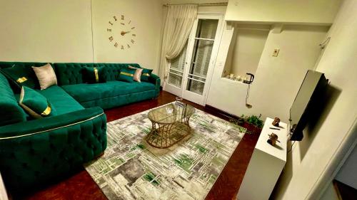 a living room with a green couch and a clock at Formidable of Cairo in Cairo