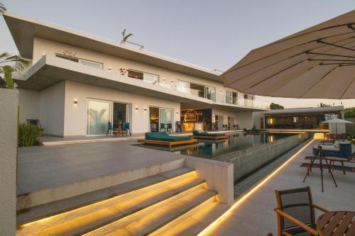 a house with a swimming pool and an umbrella at The View - Adults Only Resort in Pipa