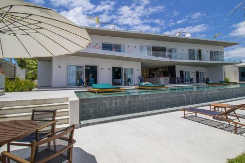 a house with a swimming pool and an umbrella at The View - Adults Only Resort in Pipa