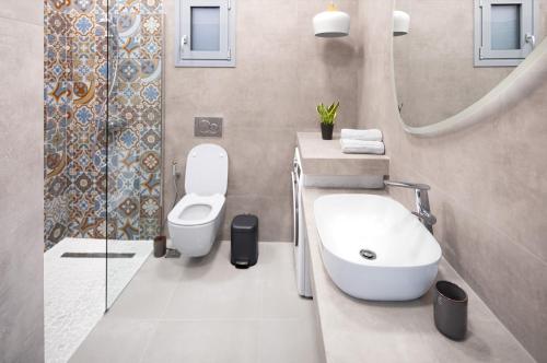 a bathroom with a toilet and a sink and a mirror at Ando’s Cozy Studio Apartment in Athens
