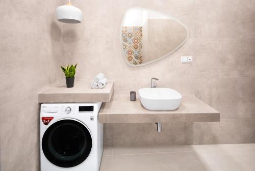 a bathroom with a washing machine and a sink at Ando’s Cozy Studio Apartment in Athens