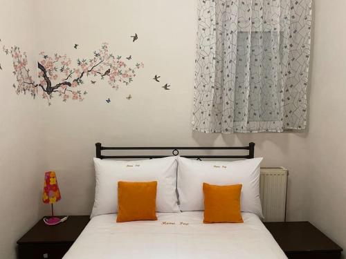 a bedroom with a white bed with orange pillows at Home Pap in Volos