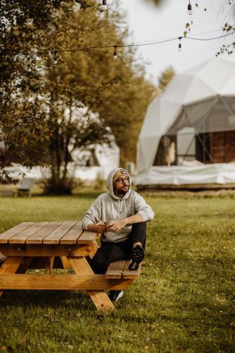 a man sitting on top of a picnic table at Czorsztyn Glamp in Maniowy