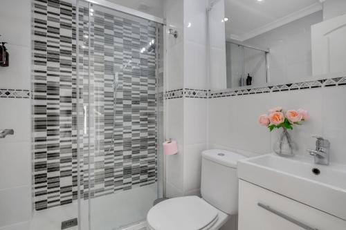トレモリノスにあるSol Montemar 10 by IVI Real Estateの白いバスルーム(トイレ、シャワー付)