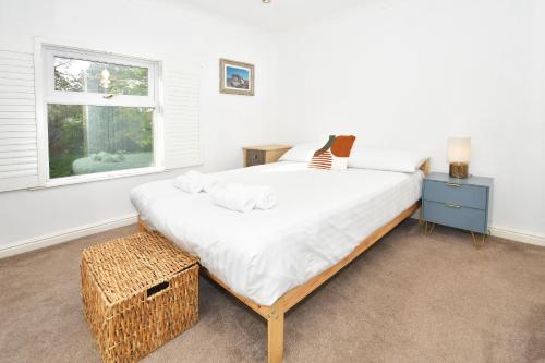 Un dormitorio con una cama grande y una ventana en Squirrel Cottage by YourStays en Stoke on Trent