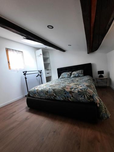 Schlafzimmer mit einem Bett und Holzboden in der Unterkunft Les Charmes de Trévoux in Trévoux