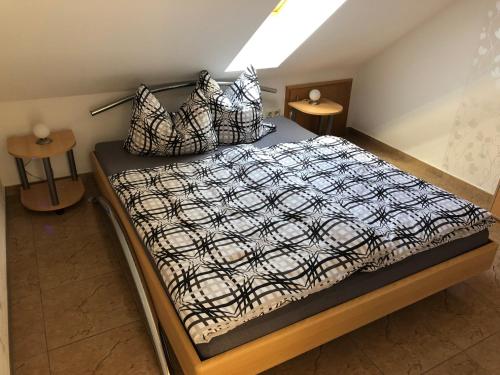 Schlafzimmer mit einem Bett mit einer schwarzen und weißen Bettdecke in der Unterkunft Ferienwohnung Graswald mit Panoramablick in die Rhön in Kaltennordheim