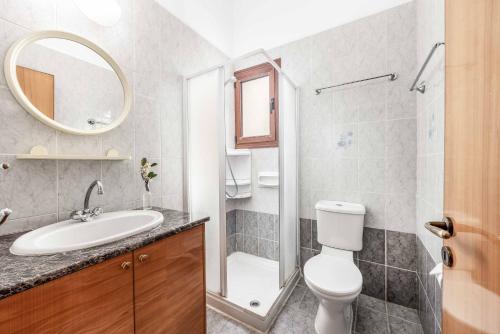 a bathroom with a toilet and a sink and a mirror at Villa Marilia in Neo Chorio
