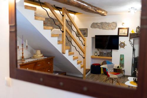 uma sala de estar com uma escada e uma televisão em Holiday Home Svjetlana em Risika