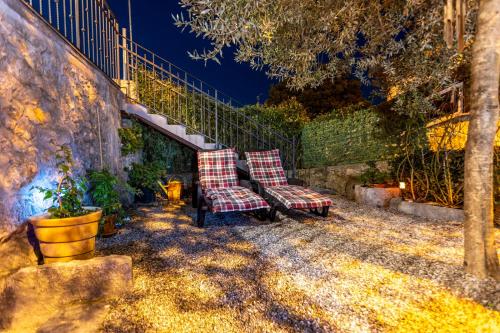 two chairs sitting on a patio at night at Holiday Home Svjetlana in Risika