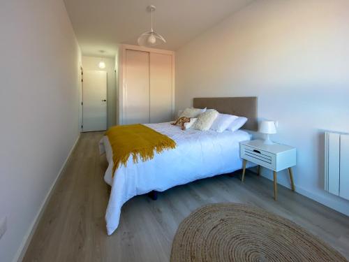 ein Schlafzimmer mit einem großen weißen Bett und einem Nachttisch in der Unterkunft O Son in Porto do Son