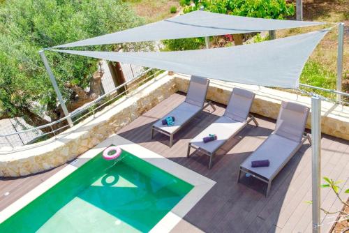 a patio with two chairs and a swimming pool at Villa Murtal in Gerani