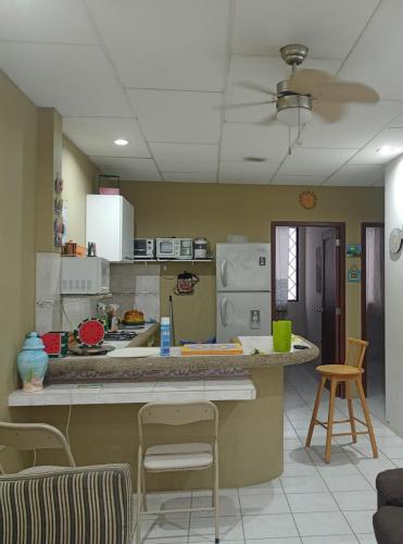 - une cuisine avec un comptoir et des chaises dans la chambre dans l'établissement Agradable villa, à Salinas
