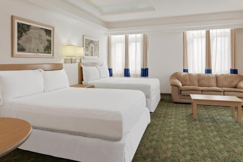 une chambre d'hôtel avec deux lits et un canapé dans l'établissement Hotel Monterrey Macroplaza, à Monterrey