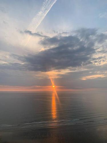 a sunset over the ocean with a rainbow in the sky at Gorgeous Gower Chalet in Swansea