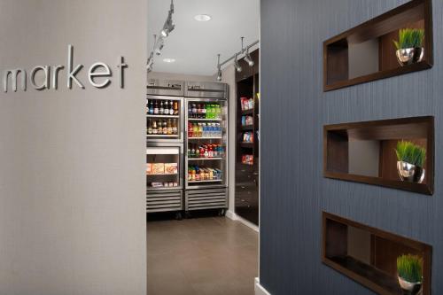 a grocery store aisle with a refrigerator with drinks at Courtyard Jacksonville Flagler Center in Jacksonville
