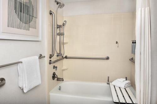 a bathroom with a white tub and a shower at Courtyard Jacksonville Flagler Center in Jacksonville