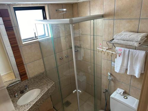 a bathroom with a shower with a sink and a toilet at apartamento com vista para o mar in Fortaleza