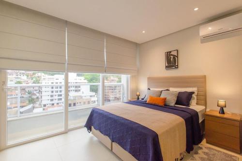 a bedroom with a large bed and a large window at Estúdio Estiloso no Pátio Milano in Florianópolis