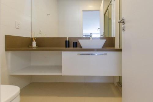 uma casa de banho com um lavatório e um WC em Estúdio Estiloso no Pátio Milano em Florianópolis