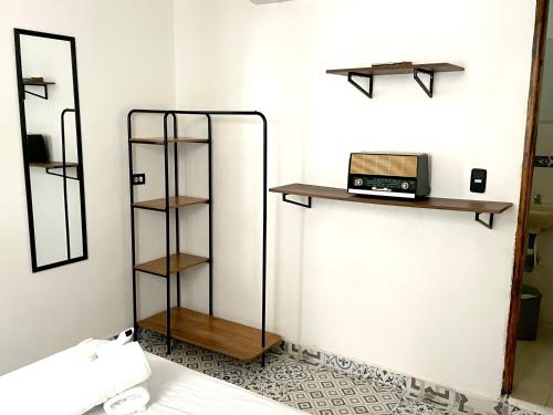 une pièce avec une étagère et un ordinateur portable sur un mur dans l'établissement Pachamama Hostel, à Carthagène des Indes