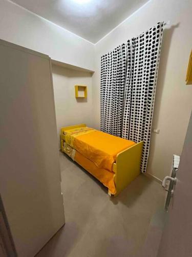 una camera con un letto con una coperta gialla di Casa Vacanze da Ciccio a Barcellona Pozzo di Gotto