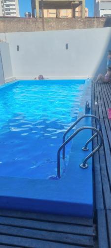 una piscina con agua azul y escaleras en ella en Cómodo monoambiente en Palermo cama King Seguridad 24 h en Buenos Aires