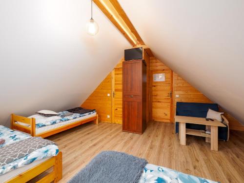 a attic room with two beds and a cabinet at Gazdówka na Mosornym Groniu in Zawoja