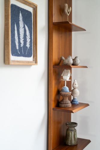 a shelf with vases and a picture on a wall at Orixás Residence in Morro de São Paulo