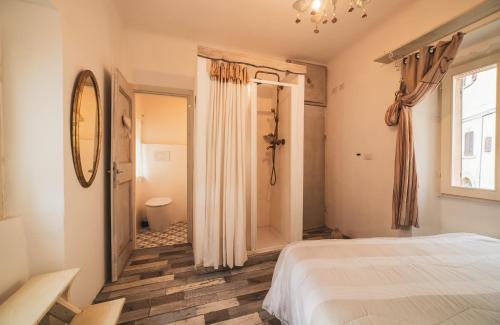 a bedroom with a white bed and a bathroom at Lake House in Sassocorvaro