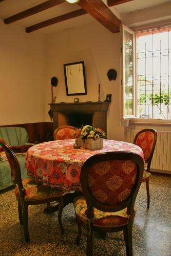 a dining room with a table and chairs and a fireplace at B&B La Bugia di Villa Tanzi in Parma