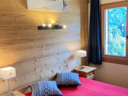 a bedroom with a wooden wall with a bed and two chairs at Appartement Avoriaz, 2 pièces, 6 personnes - FR-1-634-60 in Avoriaz