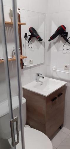 a bathroom with a sink and a toilet and a mirror at Los pisitos de El Barraco 1 in El Barraco