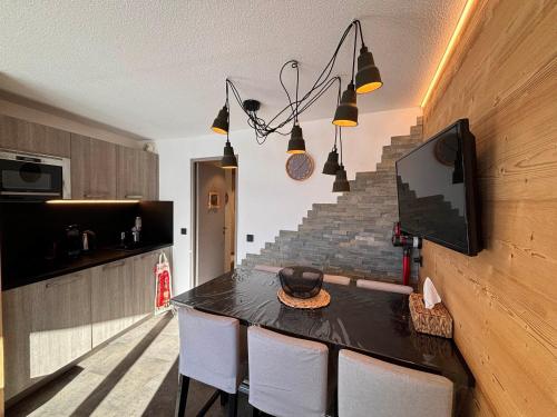 une cuisine avec une table avec des chaises et une télévision dans l'établissement Appartement Moderne pour 4/5 pers. avec Balcon Sud, Proche Accueil Station et Commerces - FR-1-634-91, à Morzine