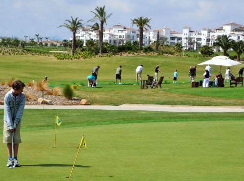 un grupo de personas jugando al golf en un campo de golf en Las Terrazas de la Torre Golf Murcia, en Murcia