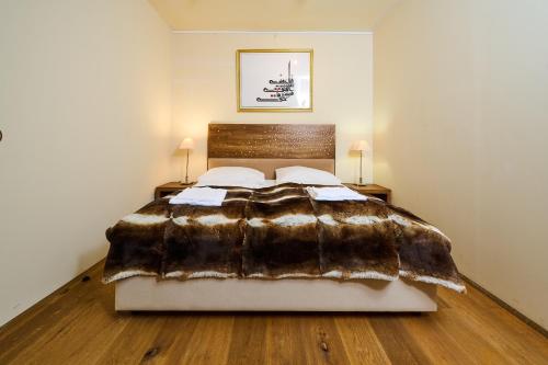 a bedroom with a faux fur bed with two lamps at Art Apartments Sievering in Vienna