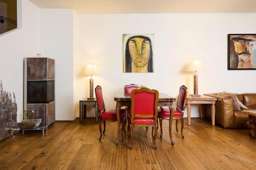 a living room with a wooden table and red chairs at Art Apartments Sievering in Vienna