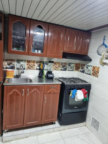 a kitchen with wooden cabinets and a stove at Lindo apartamento totalmente Amoblado in Bogotá