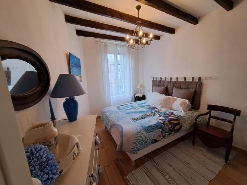 une chambre avec un lit avec un miroir et une chaise dans l'établissement Le gîte et le cottage de Sainte Valière Piscine et SPAS, à Sainte-Vallière