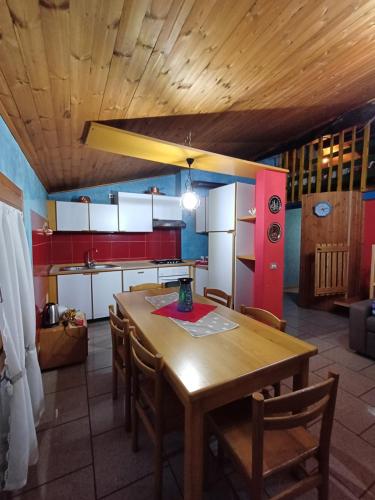 cocina con mesa de madera y algunas sillas en CASA VACANZE CA' MORESCHI, en Berzo
