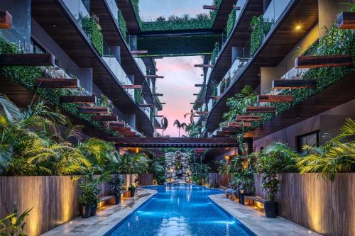 a swimming pool in the middle of a building with plants at Fast-Wifi Sunset Studio Tulum with Rooftop and Pool SPA in Tulum